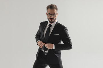 Confident man buttoning his suit jacket