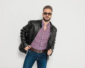 Cool fashion man adjusting leather jacket