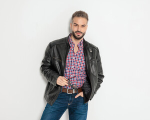 Serious casual man holding sunglasses with hand in pocket