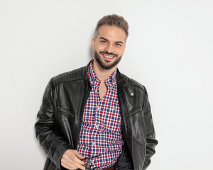 Happy bearded man holding sunglasses and smiling