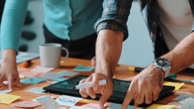 Skilled business team looking at laptop and pointing logo design while making decision to choosing main theme color and planning marketing campaign. Smart start up group working together. Symposium.