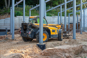 Telescopic handler at a construction site. Construction equipment for loading. Front-end loader for lifting loads, a forklift at a construction site, construction work.