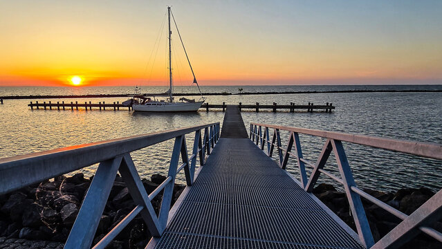 Sunset Reflections at the Marina with Sailboats and Pier