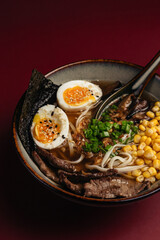 Asian dish soup on a burgundy background is delicious, must try