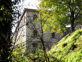 Stone architecture of the Holy Monastery of Panagia Kalamous in Xanthi, Greece. Traditional building surrounded by green trees and soft daylight, showcasing the region&rsquo;s cultural and religious heritag