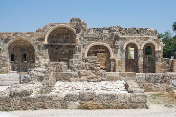 Ancient ruined stone buildings with multiple arches in the city of side, Turkey Open-air museum. Sunny weather, blue sky