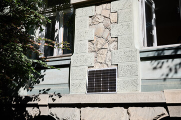 Photovoltaic solar panel in front of historical building. Concept of integration of sustainable renewable energy sources into old architecture.