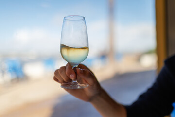 Holding glass manzanilla wine enjoying sunny outdoor environment