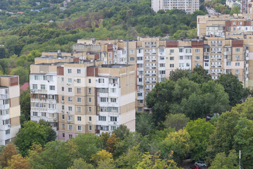 Fototapeta premium Urban residential buildings surrounded by green trees - city housing panorama