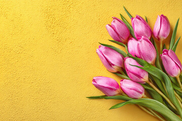 A bright yellow background complements a bouquet of delicate pink tulips