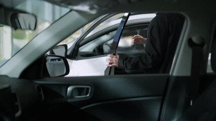 Car buyers exploring vehicles with sales agent assistance at dealership