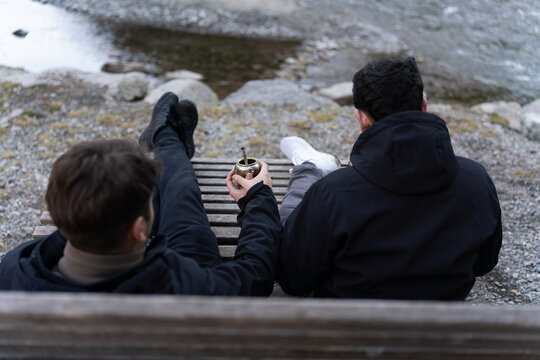 Two men sharing mate relaxing by river