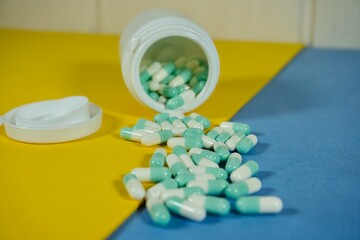 Medical capsules spilling from bottle, health treatment concept