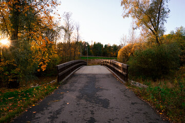 Pedestrian Bridge with Wooden Railing Surrounded by Golden Autumn Colors in Raisio, Finland.