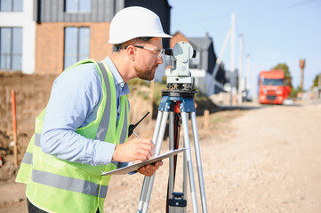 Construction engineer surveying new road development site