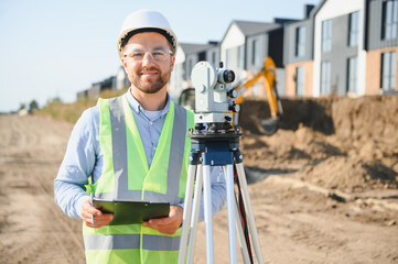Surveyor working on land measurements at construction site
