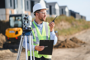 Construction engineer communicating on walkie talkie at building site
