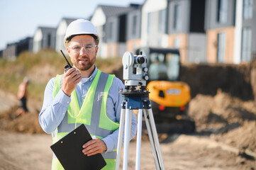 Surveyor working on construction site with theodolite