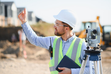 Surveyor engineer supervising construction site work outdoors
