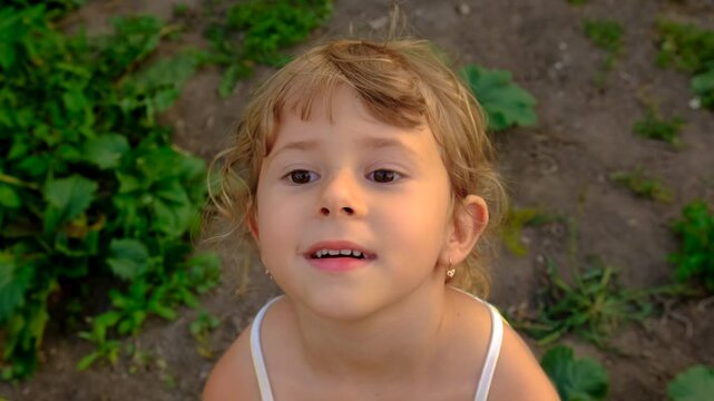 A child portrait squints on the street. Selective focus.