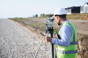 Surveyor checking precise land measurements for construction site