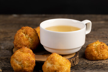 sweet cookies with coconut pieces are on the table, a group of sweet and delicious freshly made cookies for a tea party, a white cup filled with hot tea