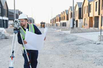 Fototapeta premium Surveyor working at new housing construction site