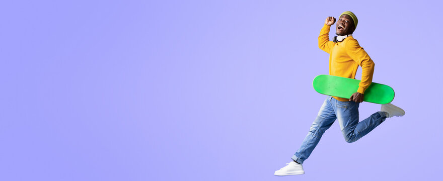 A young man with a bright smile is running energetically while holding a green skateboard. He wears a yellow sweater and blue jeans, radiating excitement and enthusiasm in a lively setting. - Powered by Adobe