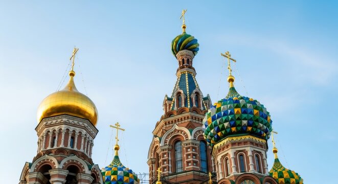 Colorful onion domes and golden cupolas of a historic cathedral against a clear blue sky, showcasing Russian Orthodox architecture for travel.