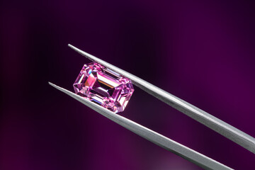 A pink diamond is displayed in a jeweler's setting