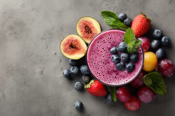 Purple smoothie bowl topped with blueberries, strawberries, kiwi slices, and grapes, arranged on a textured gray surface for colorful breakfast and health imagery.