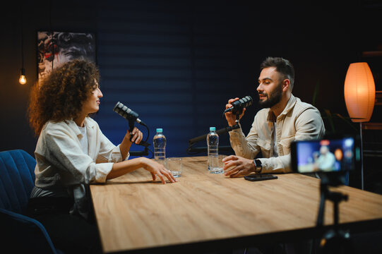 Podcasters recording audio content in modern studio