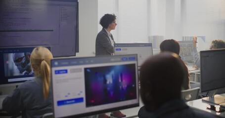 Female Teacher Stands By Large Screen Displaying Programming Code, Explaining Modeling Concepts to Adult Students. Concept Digital Education, Coding Skills, Modern Professional Learning Environment. - Powered by Adobe