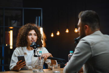 Two content creators recording podcast in modern studio