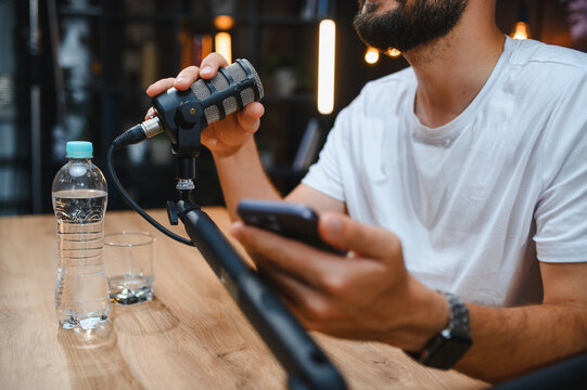 Content creator recording podcast with professional microphone and smartphone