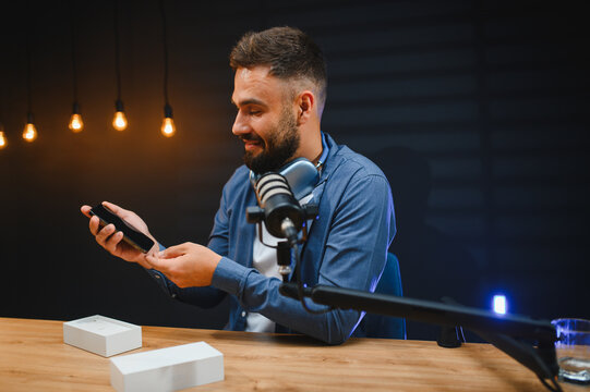 Video blogger recording content in home studio with smartphone and microphone