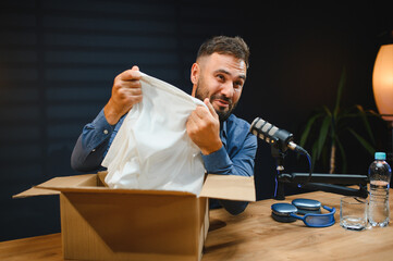 Video blogger unboxing clothes during live podcast recording