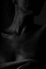 Sensual black and white portrait of wet female body with towel in dramatic lighting