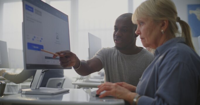 Elderly Woman Listens Attentively as Young African American Teacher Guides Through AI Prompt Creation on Computer. Concept Technology Accessibility, Digital Literacy, Inclusive Education For Seniors.