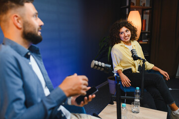 Podcasters recording audio content in modern studio
