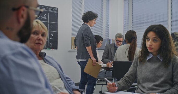 Circle of Adult Learners Participates in Classroom Workshop, With Mature Teacher Leads Speaking Group. Concept of Attentiveness and Involvement, Professional Yet Relaxed Educational Environment. - Powered by Adobe