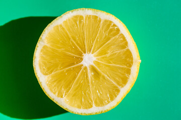 A vibrant yellow lemon resting on a table, captured in soft natural light. The image highlights the fruit&rsquo;s bright color, fresh texture, and simple composition, making it suitable for food photography