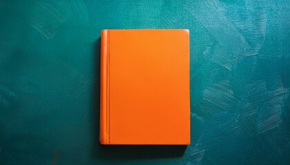 an illustrated bright orange book sits against a textured teal background exuding a sense of creativity and inspiration ideal for educational themes or reading concepts