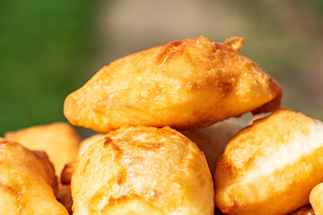 Golden, freshly fried fritters arranged on a plate, featuring a crispy exterior and a soft, airy inside. Warm lighting enhances their rich golden color and homemade rustic appearance. 