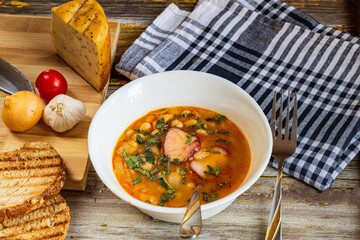 A hearty bowl of cooked bean stew with tender pieces of meat, served in a clean white dish. The warm, rich broth highlights the soft beans and juicy meat, while natural lighting 