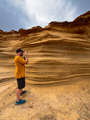 Photographer Capturing a Unique Sandstone Rock Formation in a Creative Way