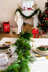 Festive dining table decorated with greenery and candles for a cozy Christmas celebration