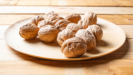 Walnuts, walnuts in their shells, and accessories positioned on a rustic table, Selective Focus.