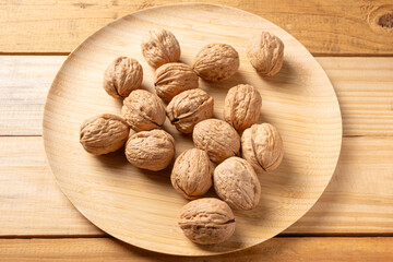 Walnuts, walnuts in their shells, and accessories positioned on a rustic table, Top view