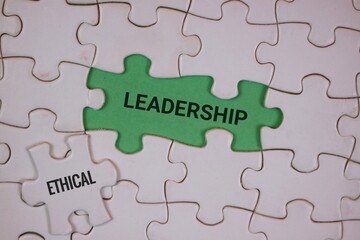 Fototapeta premium puzzle pieces with a green piece in the center labeled “LEADERSHIP,” accompanied by another piece labeled “ETHICAL,” symbolizing the connection between strong leadership and ethical principles. 